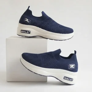 Women's navy blue breathable slip-on knit walking shoes with thick cushioned white sole displayed on a white studio pedestal.