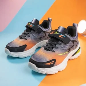 Kids lightweight grey and black sports running shoes with orange accents, breathable mesh upper, hook-and-loop strap, cushioned sole, and athletic sneaker design.