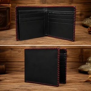 Open and semi-folded black genuine leather bifold wallet with prominent red contrast hand stitching on a dark wood background